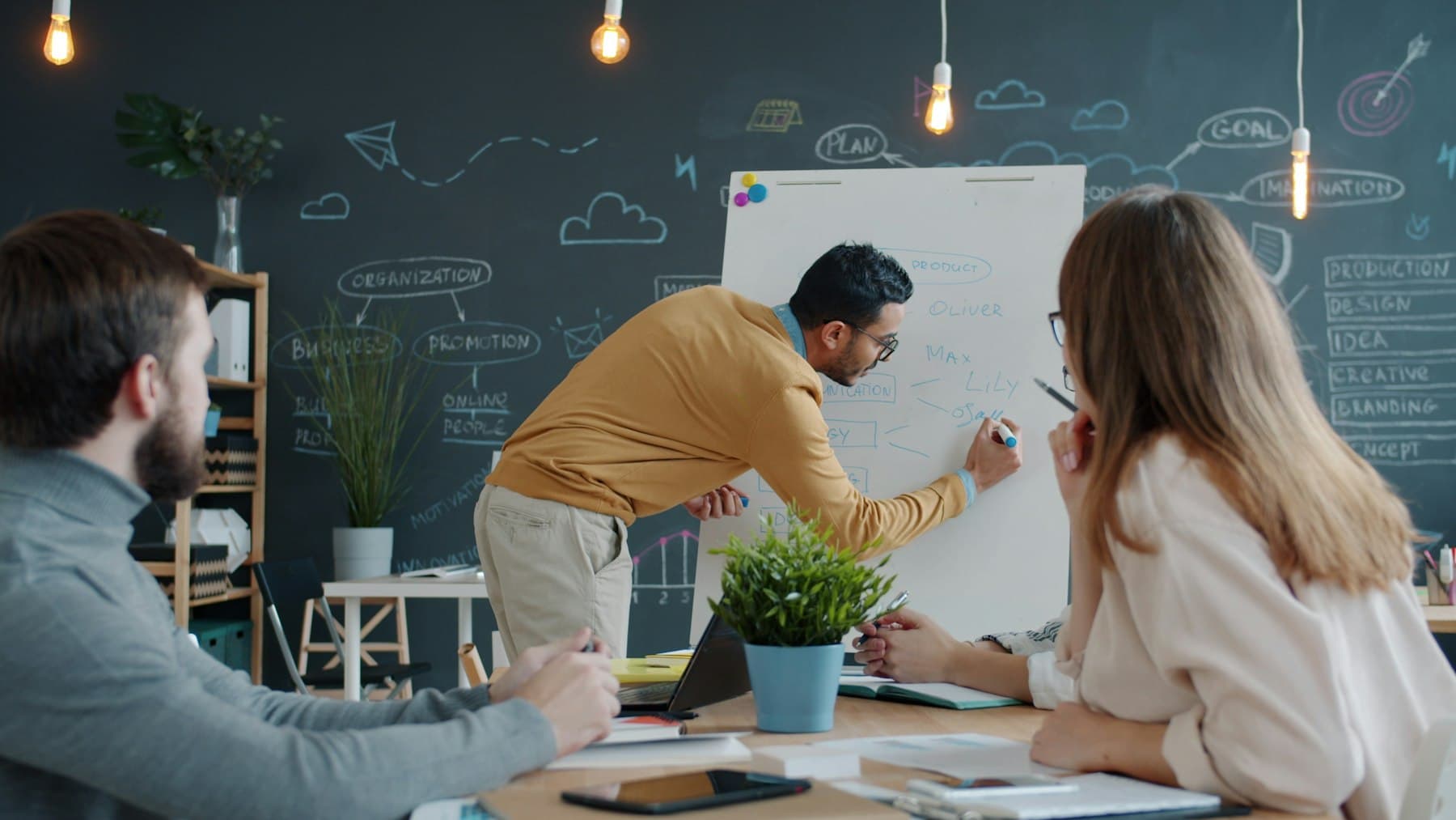 A founder sketching ideas on a whiteboard for the team