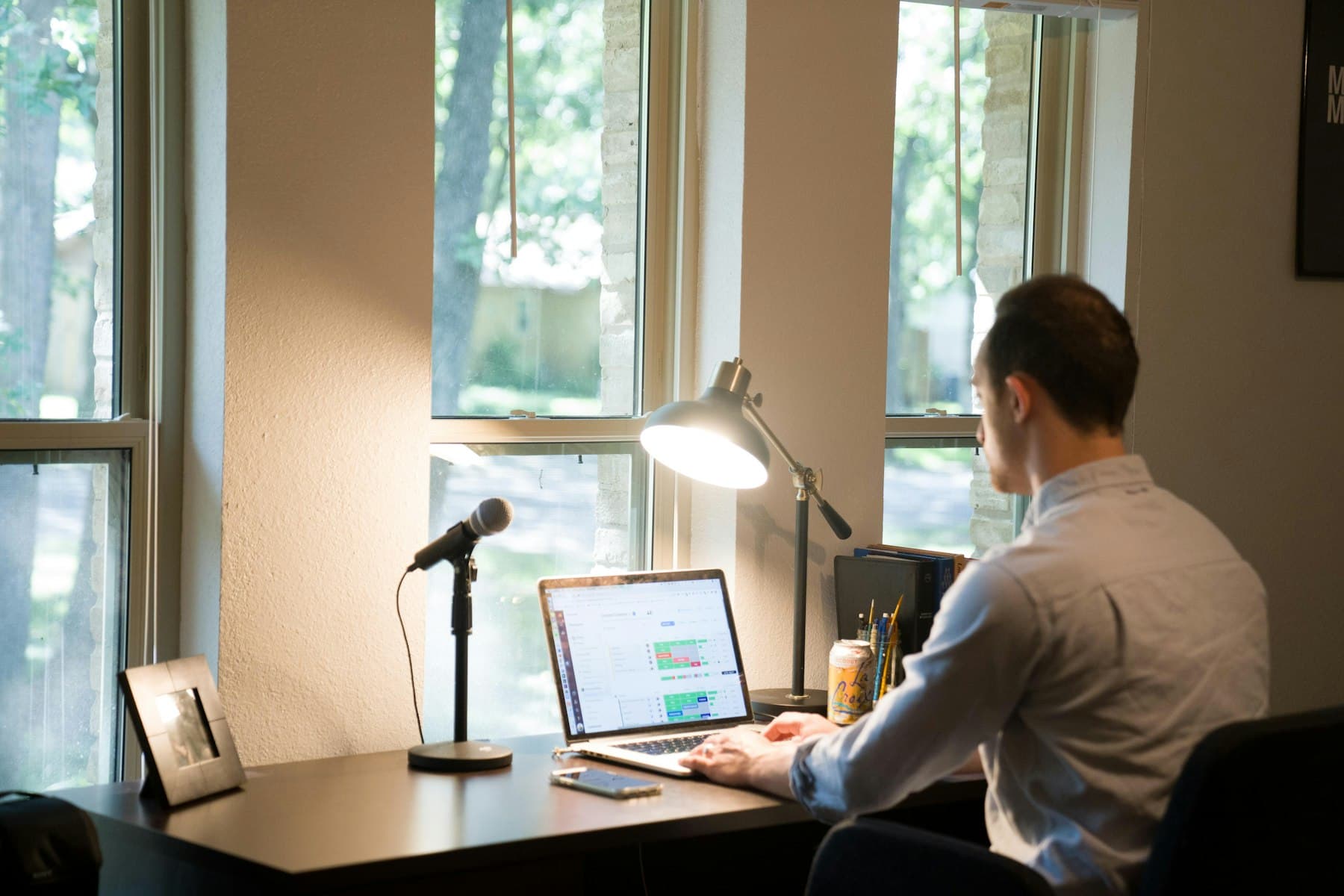 An engineer working at a home desk next to a window